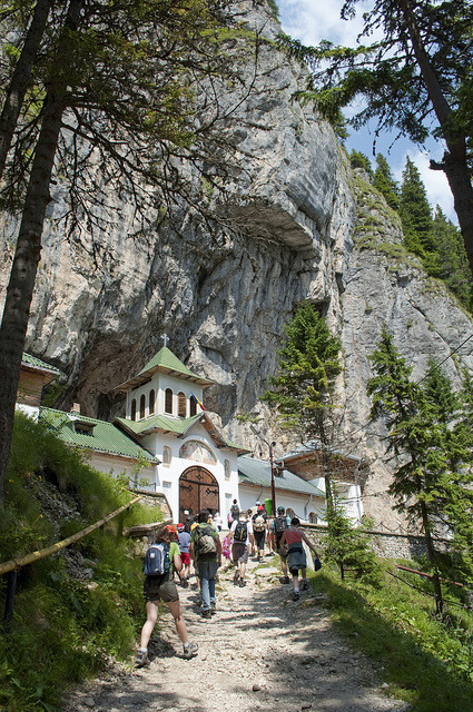 The outside of Pestera Monastery, which has a cave behind it, Romania